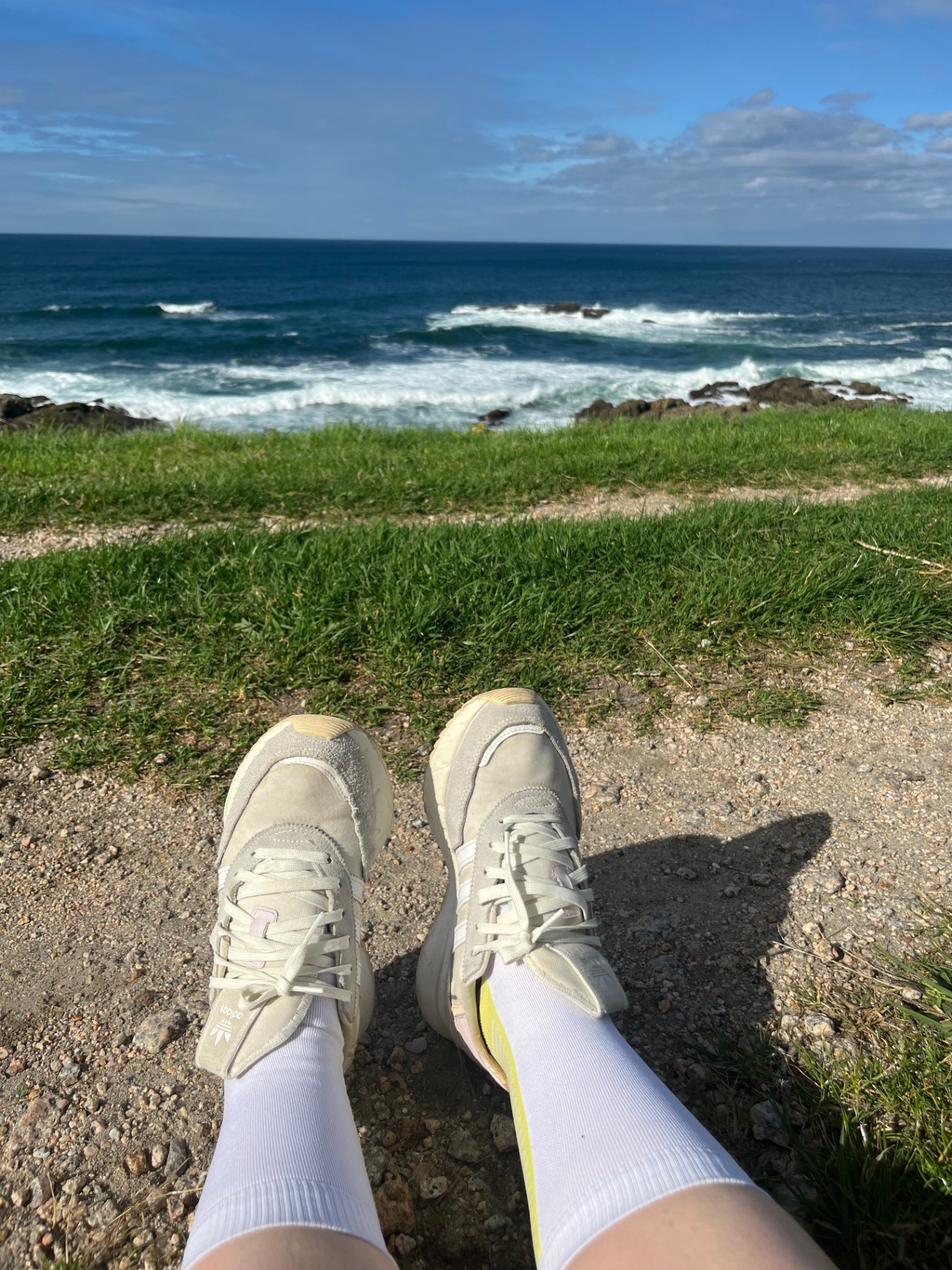 Picioare pe nisip lângă ocean